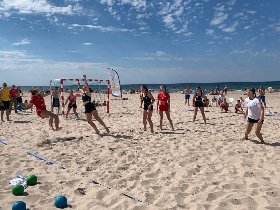 mecz piłki ręcznej na plaży, zawodniczki grają, w tle morze