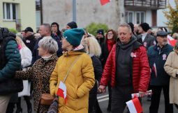 marsz ulicami, uczestnicy rozmawiają, niosą choragiewki