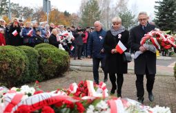 składanie wiązanek kwiatów pod pomnikiem - w tle uczestnicy uroczystości