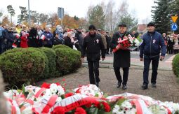 składanie wiązanek kwiatów pod pomnikiem - w tle uczestnicy uroczystości