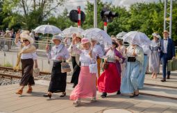 Letnicy w strojach historycznych przechodzą przez tory