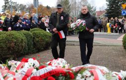 składanie wiązanek kwiatów pod pomnikiem - w tle uczestnicy uroczystości