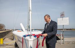 Burmistrz odwiązuje wstążkę, łódź, w tle morze