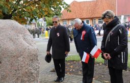 składanie wiązanek pod pomnikiem, w tle uczestnicy