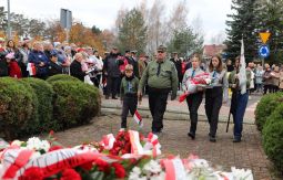 składanie wiązanek kwiatów pod pomnikiem - w tle uczestnicy uroczystości