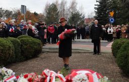 składanie wiązanek kwiatów pod pomnikiem - w tle uczestnicy uroczystości