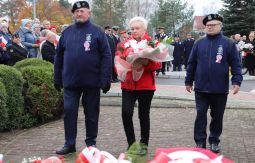 składanie wiązanek kwiatów pod pomnikiem - w tle uczestnicy uroczystości