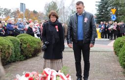 składanie wiązanek kwiatów pod pomnikiem - w tle uczestnicy uroczystości