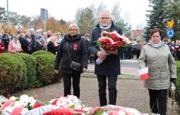 składanie wiązanek kwiatów pod pomnikiem - w tle uczestnicy uroczystości