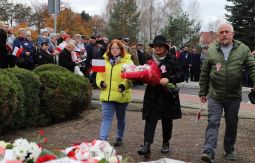 składanie wiązanek kwiatów pod pomnikiem - w tle uczestnicy uroczystości