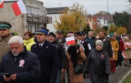 marsz ulicami, uczestnicy rozmawiają, niosą choragiewki