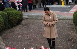 składanie wiązanek kwiatów pod pomnikiem - w tle uczestnicy uroczystości