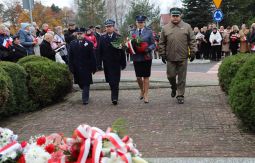 składanie wiązanek kwiatów pod pomnikiem - w tle uczestnicy uroczystości