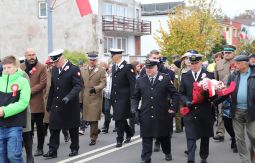 marsz ulicami, uczestnicy rozmawiają, niosą choragiewki