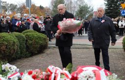 składanie wiązanek kwiatów pod pomnikiem - w tle uczestnicy uroczystości